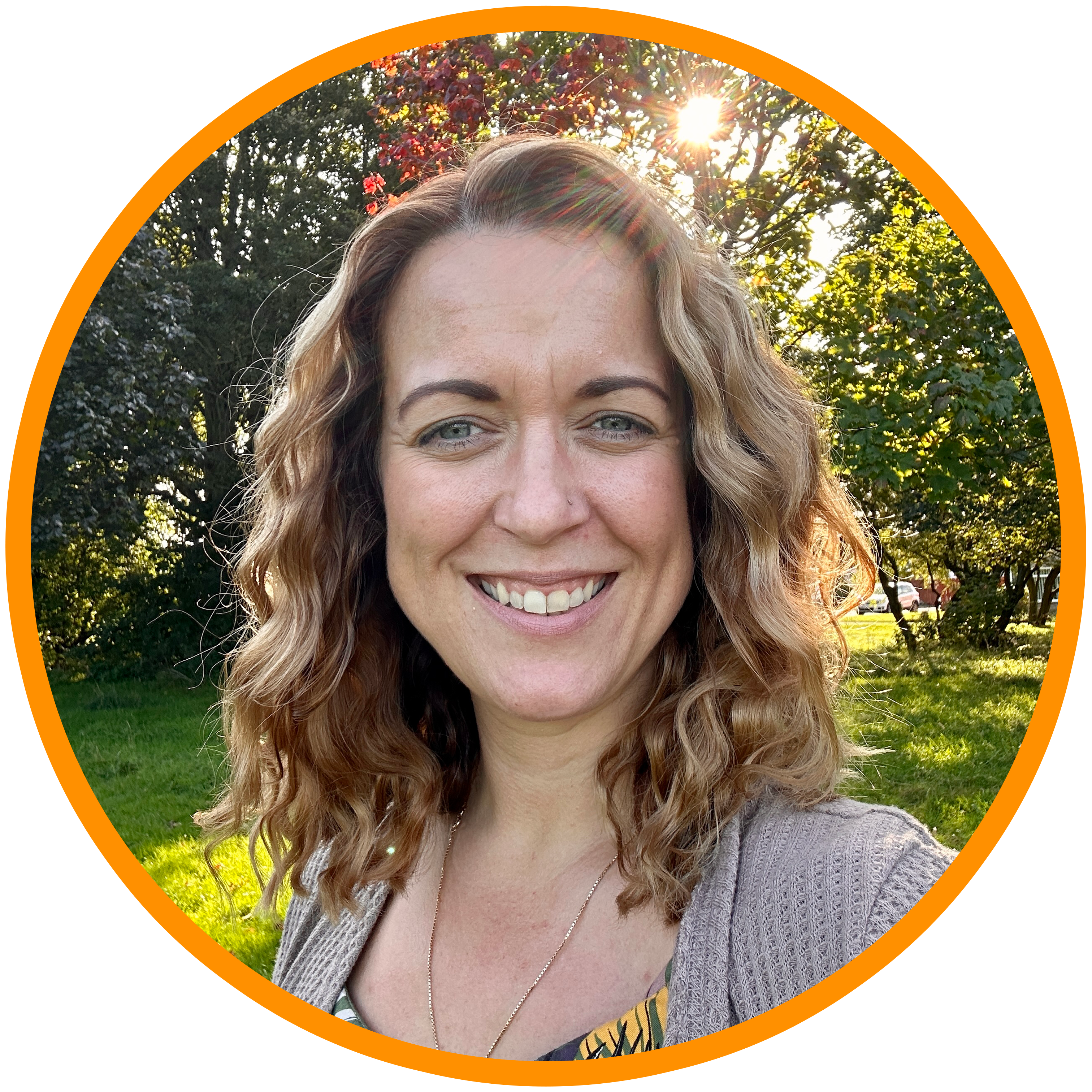 Photo of Vikki with pink top she has brown wavy hair and is smiling